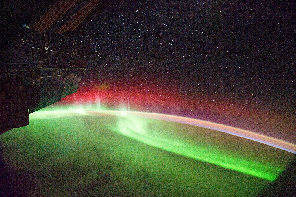 Photo of bright green and red aurora from space
